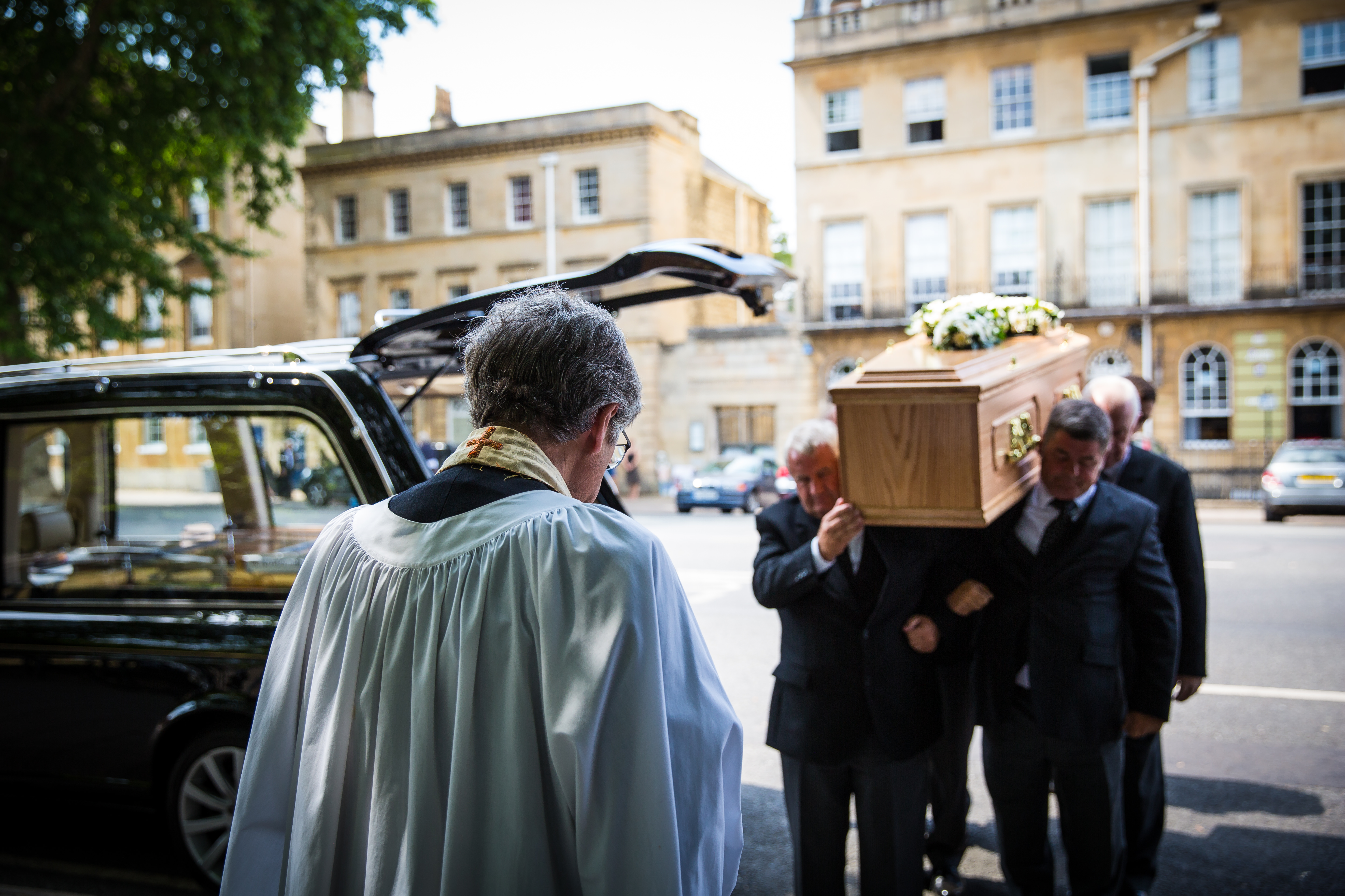 officiant standing infront of the pallbearers as they bring the casket into the venue